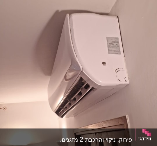 מזגן לבן מותקן על קיר פנימי בחדר